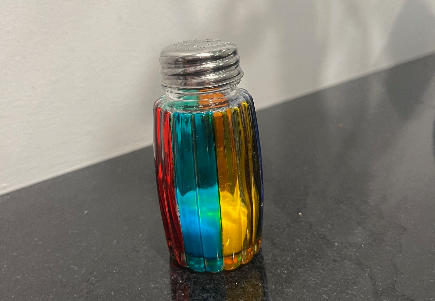 A beautiful, rainbow-hued stained-glass salt shaker